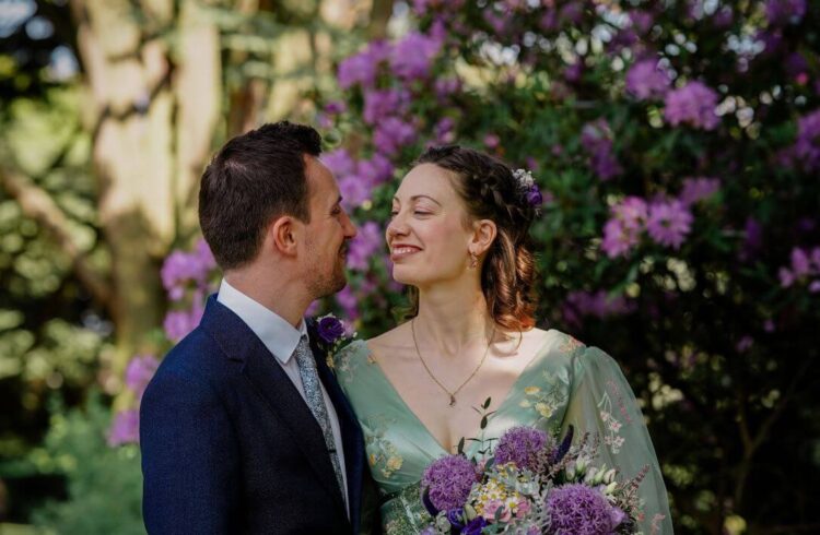 A wedding couple in front of rhododendrons