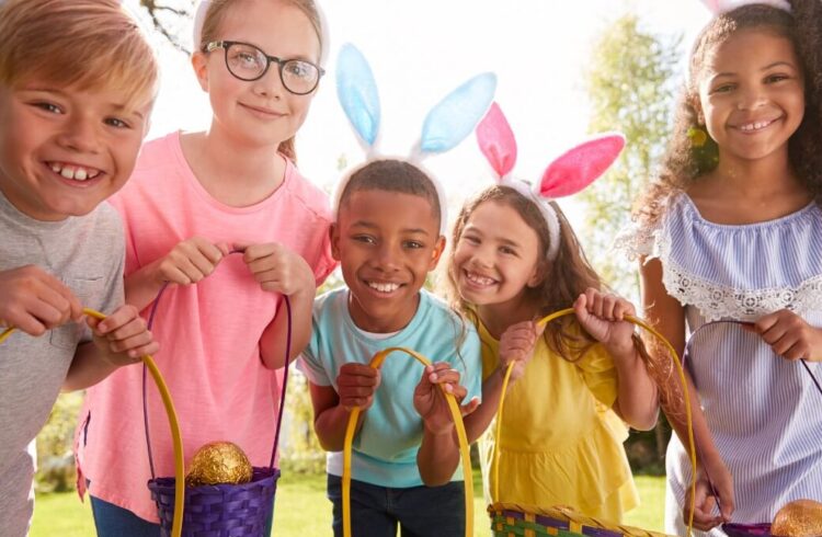 Five children with bunny ears show off their egg baskets