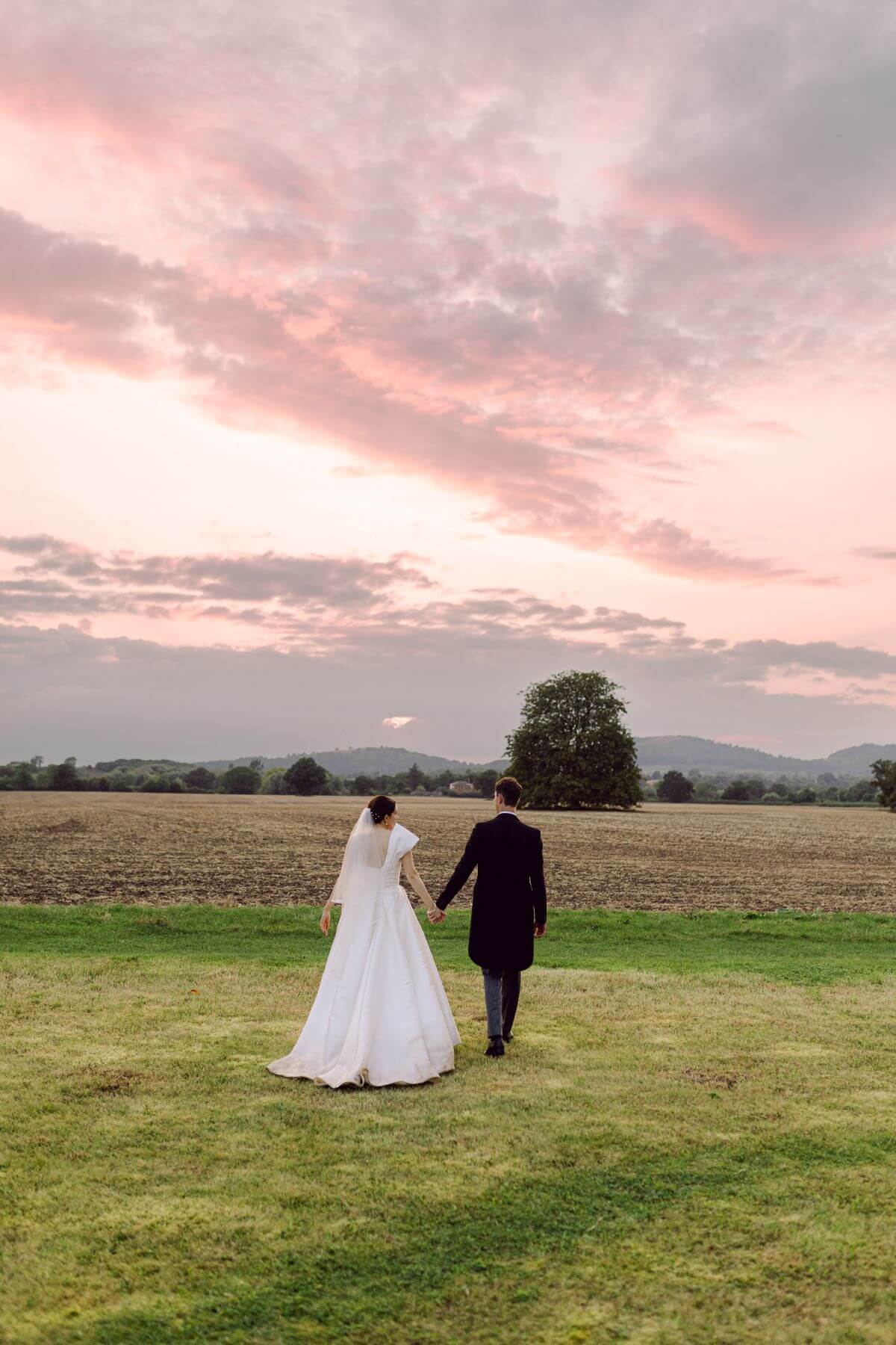 A couple walking into the sunset on their wedding day