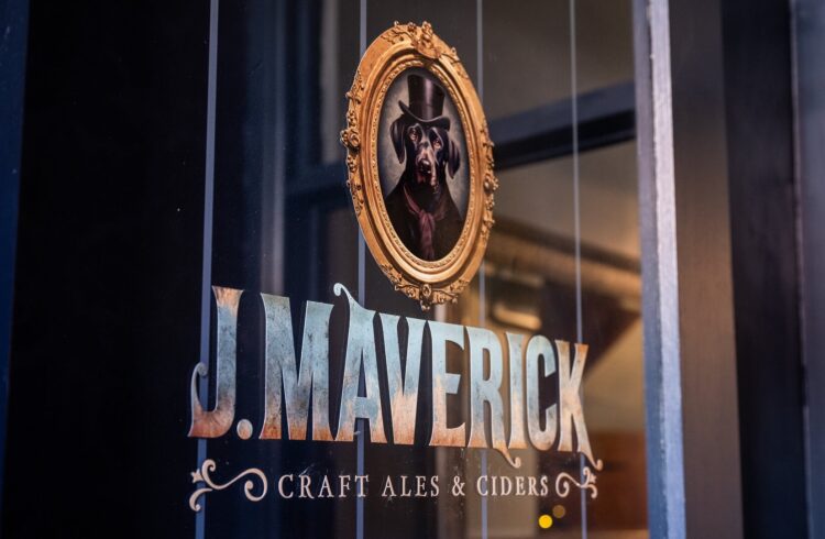 J Maverick branding on glass with framed picture of a dog wearing a top hat