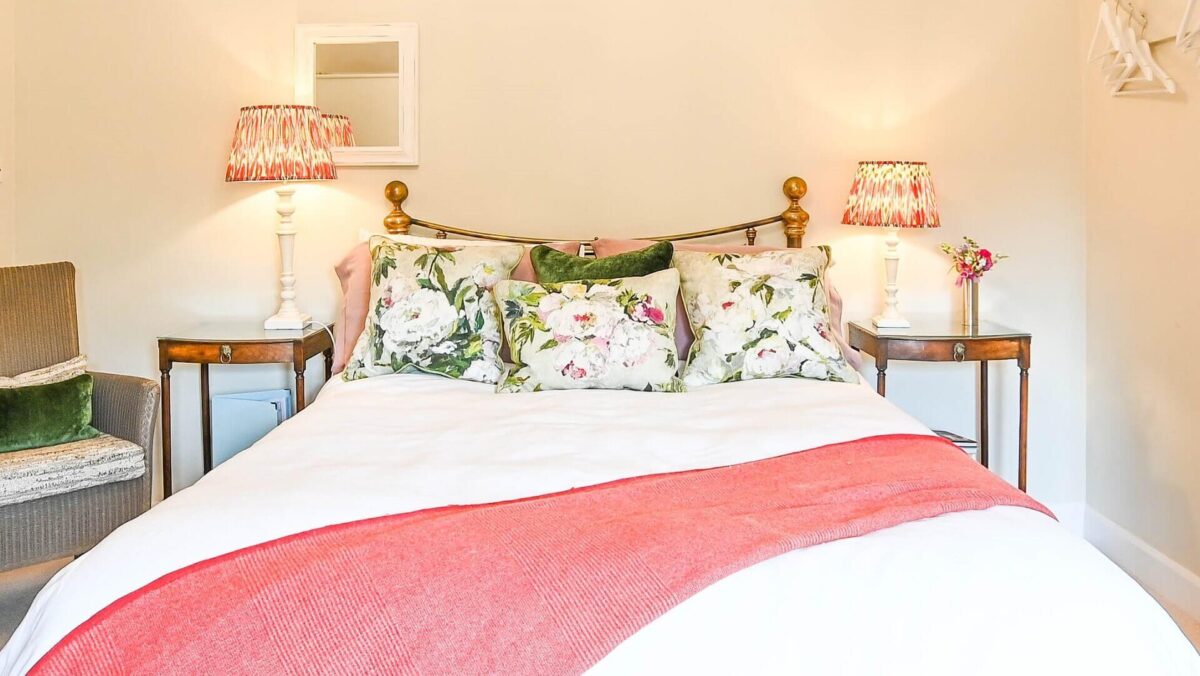 Bedroom at Morningside Cottage with bed, two bedside tables and chair visible