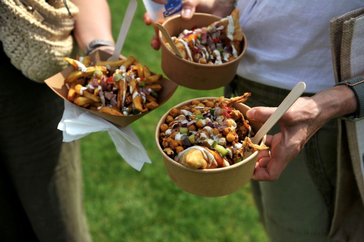 three people holding  indian street food